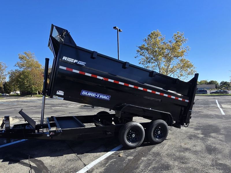 Arch City Property Care's black tandem-axle dump trailer with the bed raised to unload