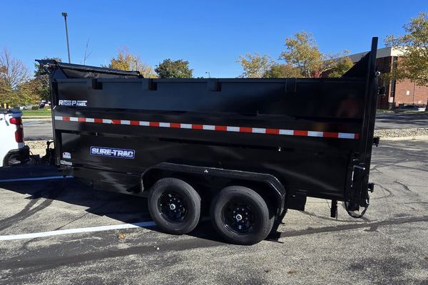 Side view of Arch City Property Care's black tandem-axle dump trailer